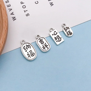 Macro shot of silver vintage alloy charms with engraved Chinese characters for DIY jewelry