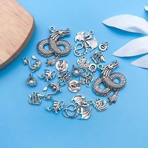 Antique silver dragon pendants with pearls for DIY jewelry making on a blue background