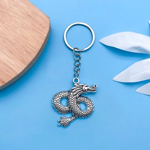 Detailed close-up of antique silver dragon pendant with intricate scale textures