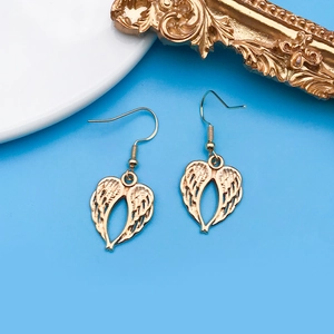 Vue macro détaillée de boucles d'oreilles ailes d'ange dorées en forme de cœur