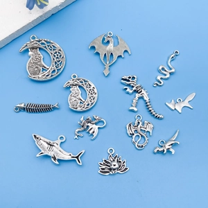 Close-up of vintage silver alloy animal charms including shark and dinosaur for DIY jewelry