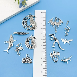 Vintage silver animal pendants shown with a ruler for precise size reference