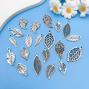 Flat lay of vintage silver alloy leaf pendants in various shapes for DIY jewelry making