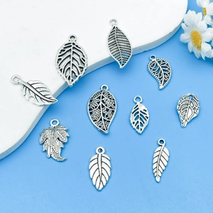 Detailed flat lay of silver vintage hollow leaf pendants for DIY jewelry making