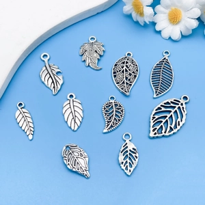 Close-up of vintage alloy leaf charms in various hollow designs for DIY jewelry making