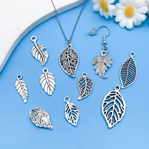 Detailed flat lay of vintage silver hollow leaf alloy pendants for DIY jewelry making