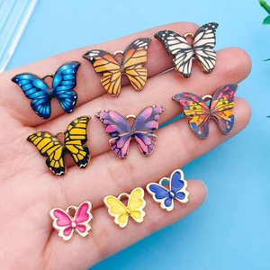 Détail de breloques papillon en émail coloré de différentes tailles pour bijoux DIY