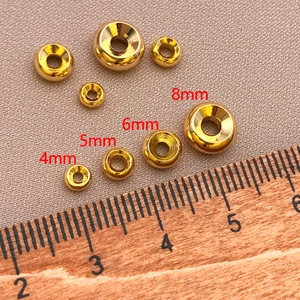 Macro view of 4-8mm gold plated wheel spacer beads shown with a ruler for size reference