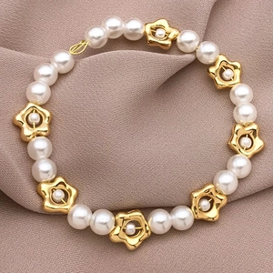 DIY 18k gold plated irregular flower beads with white pearls on a pink textile background