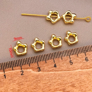 Macro detail of 18k gold plated star spacer beads with 10mm measurement on a wooden ruler