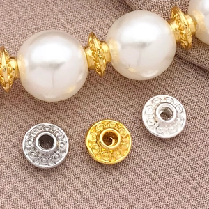 Detailed macro view of 18K gold and silver plated spacers on a pearl bracelet