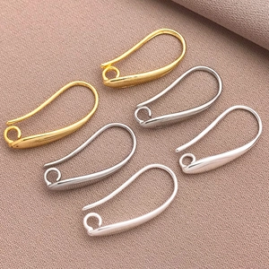 Dettaglio di sei orecchini a spilla da balia placcati oro 18 carati e argento su tessuto