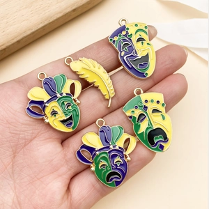 Macro detail of Mardi Gras carnival masks and yellow feather charms in gold-toned alloy