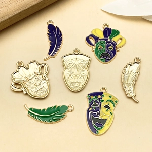 Detail shot of Mardi Gras style enamel charms featuring purple green and yellow feathers and masks
