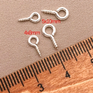 Macro detail of 4x8mm and 5x10mm silver eye pins for DIY jewelry making on fabric