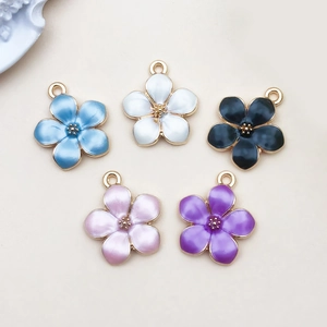 Detail of five-piece colorful enamel flower charms with gold centers for DIY jewelry