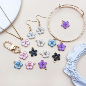 Detailed close-up of mixed enamel flower charms with gold-plated jewelry accessories
