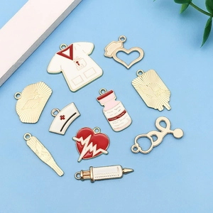 Flat lay of medical themed enamel charms including stethoscope and syringe on blue background