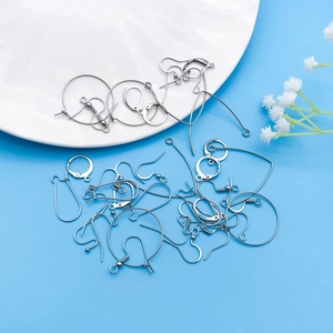 Flat lay of diverse stainless steel DIY earring hooks on a vibrant blue background