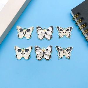 Detailed macro view of 6-piece gothic skull butterfly enamel charms for DIY jewelry making