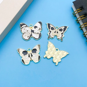 Macro shot of Gothic skull butterfly pendants with black and white enamel finish