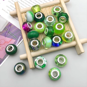 Detailed view of green cartoon resin large hole beads with metal core on bamboo tray