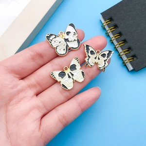Macro shot of three Gothic butterfly pendants with skull details for DIY jewelry making