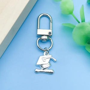 Détail des breloques chapeau de diplômé en argent sur un porte-clés en métal avec clip
