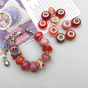 Detailed close-up of DIY red large hole bead bracelet with silver heart pendant charms