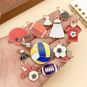 Detail of colorful sports-themed enamel charms held in hand for DIY jewelry making