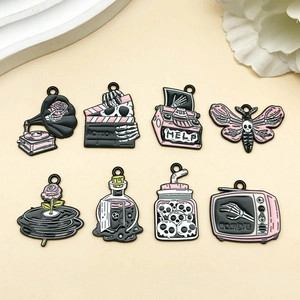 Detailed flat lay of eight pink and black Gothic enamel Halloween charms for jewelry making