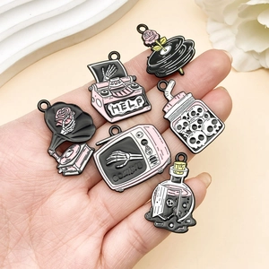 Macro detail of six pink Gothic enamel charms with skull hand and typewriter motifs