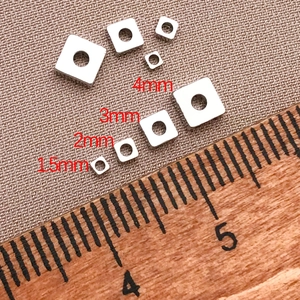 Detail showing various sizes of 18K gold plated square spacer beads for jewelry making
