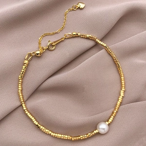 Détail du bracelet perles carrées plaqué or 18k avec une perle blanche centrale