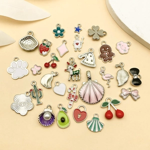 Primer plano de dijes coloridos de esmalte para joyería DIY incluyendo fresa y corazón