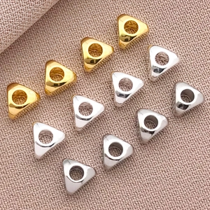 Détail macro de perles d'espacement triangulaires plaquées or 18k pour bijoux DIY