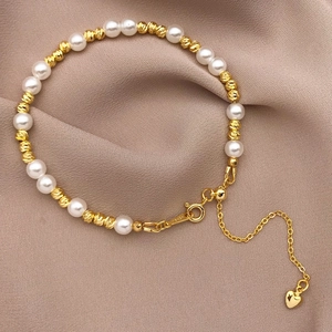 Detail of 18K gold plated U-shaped clasp and lobster buckle on a pearl bracelet