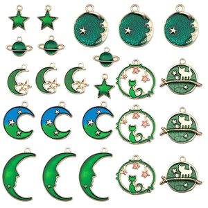 Detalle de dijes de esmalte de luna, estrella y gato para creación de bisutería
