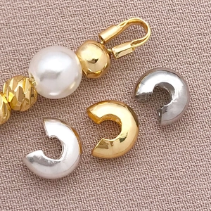 Macro detail of 18K gold and silver C-shaped crimp bead covers for jewelry making