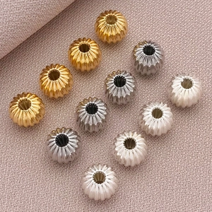 Primer plano de cuentas de calabaza bañadas en oro 18K y cuentas rayadas para joyería DIY