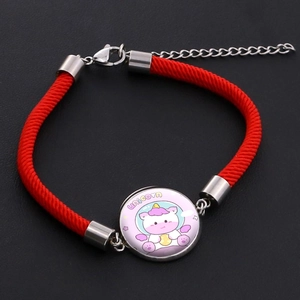 Close-up of woven red rope bracelet with cartoon unicorn glass charm and metal clasp