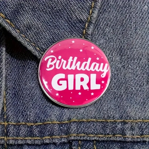 Badge rose Birthday GIRL épinglé sur une veste en jean bleue pour fête d'anniversaire