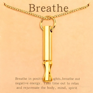 Primer plano del colgante dorado para respiración y meditación con cadena box