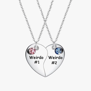 Close-up of split heart necklaces with pink and blue stones and Weirdo engraving
