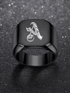 Détail macro de la lettre gothique A sur une bague chevalière en acier inoxydable noir