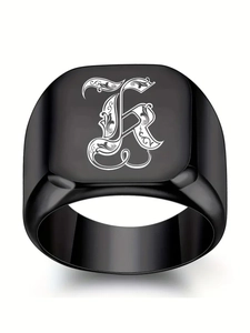 Détail d'une bague chevalière noire mate avec lettre gothique K blanche gravée dessus