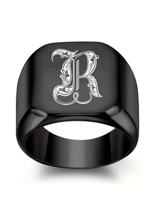 Vue macro d'une bague chevalière noire en acier inoxydable avec la lettre gothique R