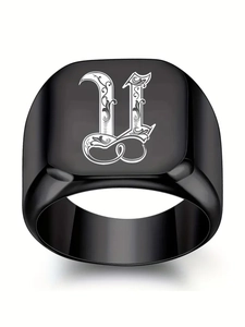 Gros plan sur bague chevalière noire en acier avec lettre gothique U et motifs ciselés