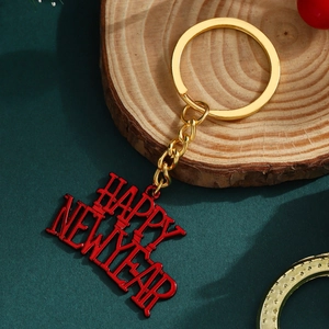 Golden Happy New Year metal keychain with red lettering on a festive background