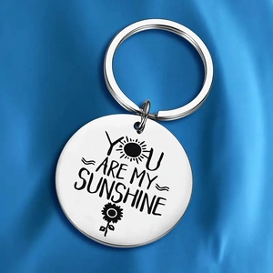 Polished stainless steel sun keychain engraved with You Are My Sunshine text on blue silk